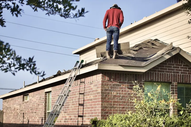 Professional roofer working on a residential roof in Alma
